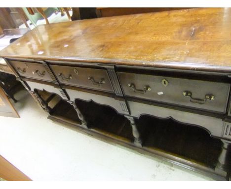 A modern oak dresser in the 18th Century manner, the plain top above three drawers above a pot shelf with baluster supports