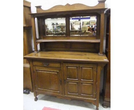 An oak Arts & Crafts mirror back sideboard, the superstructure with a pair of mirrors above a shaped shelf, flanked by fluted