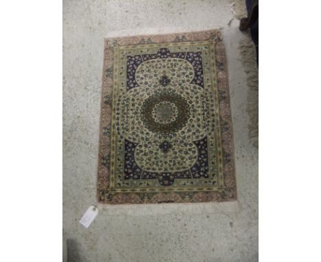 A Persian silk rug, the central circular medallion in cream, eau de nil, blue, green and cinnamon on a cream trailing foliate