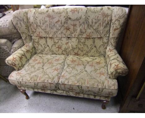 A modern cottage style two seat sofa with gold and fuschia patterned upholstery, together with a two seat cane conservatory s