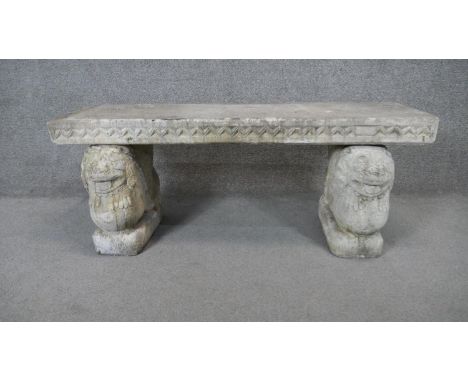 A Classical style concrete garden bench with platform seat on twin lion supports. H.47 W.120 D.40 