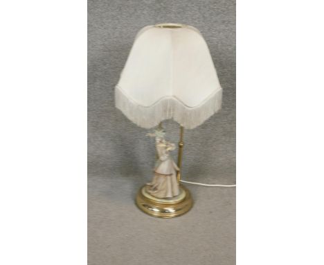 A porcelain and brass figural table lamp, 19th century style lady on scroll base. H.68cm 