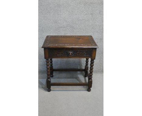 A mid century oak side table with mask carved frieze drawer on bobbin turned supports. H. 79 W. 69 D. 45 