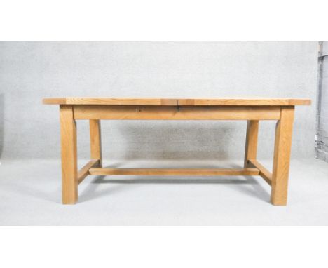 A contemporary John Lewis light oak planked top extending dining table on stretchered square supports. H. 77 W. 180 D. 95 (W.