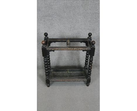 A mid century carved oak umbrella stand on bobbin turned supports with lift out metal drip tray. H 60 W.60 D.26 