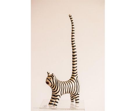 A wooden model of a stripey cat with upright tail, initialled WT, 31cm tall.
