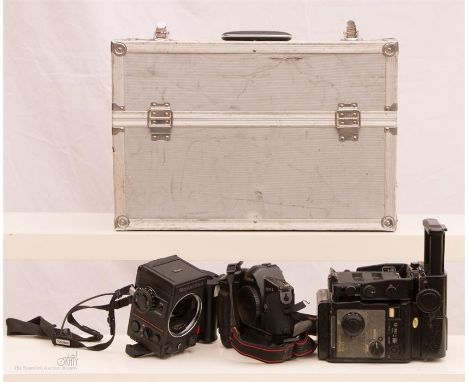 Three professional camera bodies in a silver metal case to include FUJI GX 680, Canon EOS- 1, Rolleiflex mod two with grip.