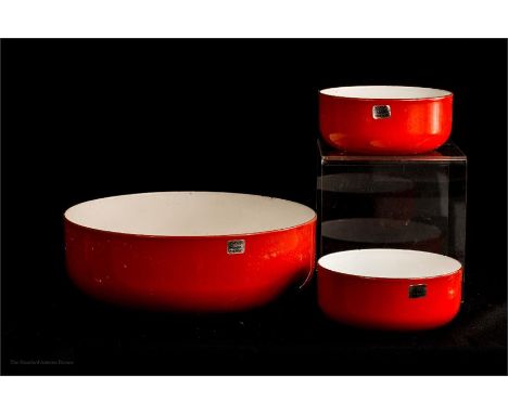 A trio of red enamel bowls with label 'Arabia Finland', one large, diameter 26cm two smaller bowls to match; diameter 14cm. 