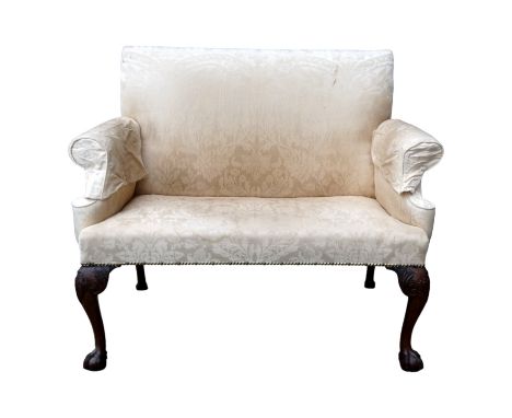 A George III mahogany two seat sofa - upholstered in cream damask and raised on ball and claw feet, width 119cm.