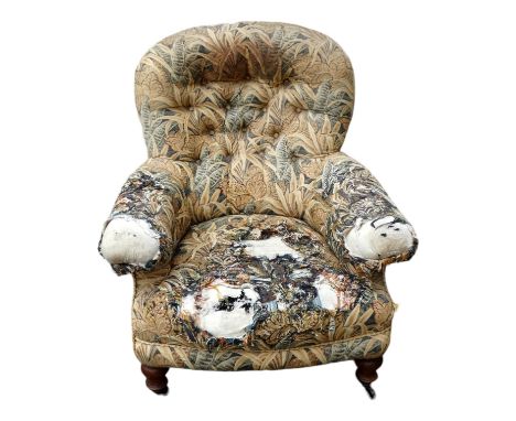 A walnut and button upholstered chair in the manner of Howard &amp; Sons - with short turned legs ending in brass castors.