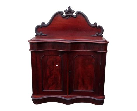 A Victorian mahogany credenza - the raised shaped back carved with fruit and flowers above a serpentine top and arrangement o