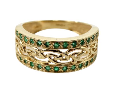 A 14ct gold emerald set dress ring - with a pierced central knot-work band set between stones, size O, 3.9g.