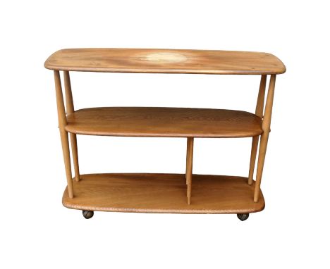 An Ercol elm and beech Baby Giraffe three tier trolley - model 361, incorporating a magazine divider and raised on castors, 9