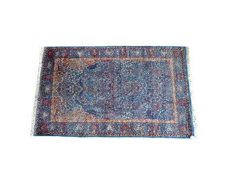 A 20th century Agra rug - scrolling foliate design on a light blue ground, 183 x 300cm.  