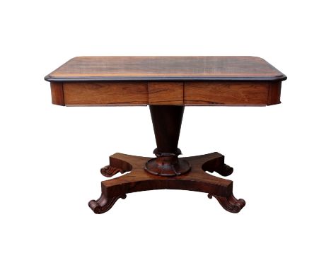 A William IV rosewood library table - the rectangular top incorporating two frieze drawers, on a tapering support and shaped 