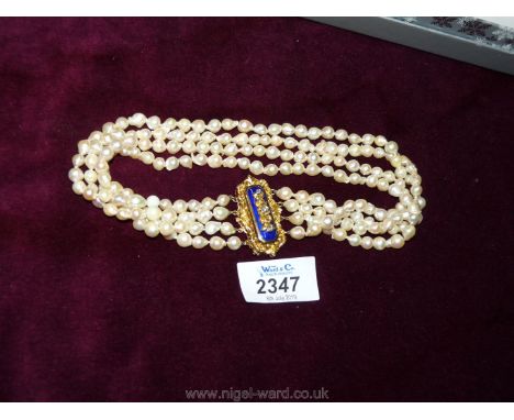 A four strand Baroque cultured pearl necklace with a gilt and enamel clasp.