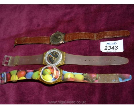 A Gentlemans wrist watch with leather strap and two swatch watches.