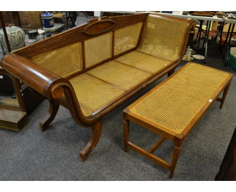 A contemporary bergere three seat sofa, cresting top rail, scrolled arms, shaped outswept legs; a long rattan coffee table (2