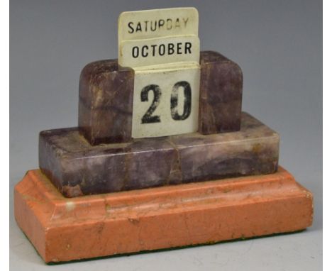 An early 20th century amethyst and rouge marble perpetual desk calendar, stepped base, 10.5cm wide, c.1930