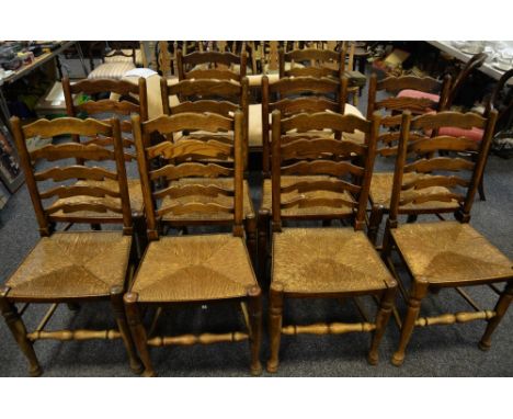 A set of ten oak ladder back dining chairs, raffia seats