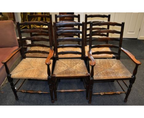 A set of six oak country ladder back chairs including two carvers, rush chairs