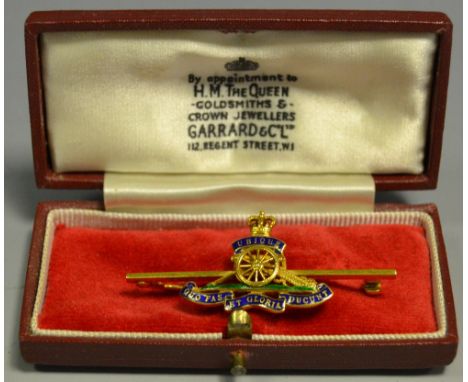 A Garrard and Co 9ct gold Royal Artillery brooch, blue enamelled Motto and cannon above a green enamel line, weight 96.2g, or