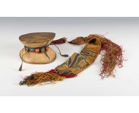 A Tibetan human skull and leather damaru (drum), 18th/19th century, the double-sided drum comprising two skull caps with stre