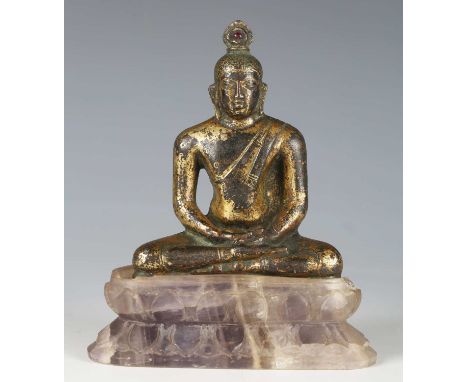 A Ceylonese gilt bronze figure of Buddha, late Anuradhapura period, 8th/9th century, modelled seated in dhyanasana holding hi