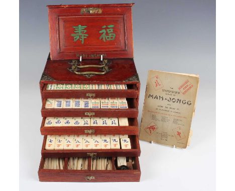 A Chinese mahjong set, early 20th century, with bone and bamboo tiles, within a brass mounted stained wood case with sliding 