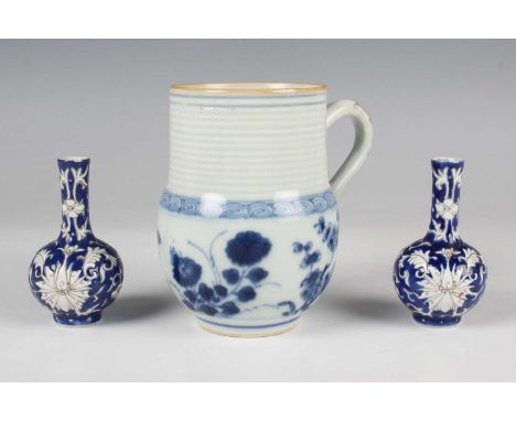 A Chinese blue and white porcelain mug, Kangxi period, the body painted with flowers beneath a ribbed cylindrical neck, heigh