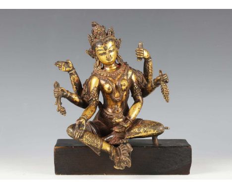 A Nepalese gilt bronze figure of Vasudhara, 12th-14th century, finely modelled seated in lalitasana wearing a five-leaved dia