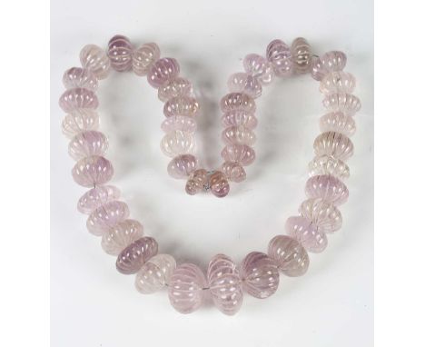 A Chinese rock crystal bead necklace, comprising forty-two amethyst tinted flattened circular beads with fluted decoration, l