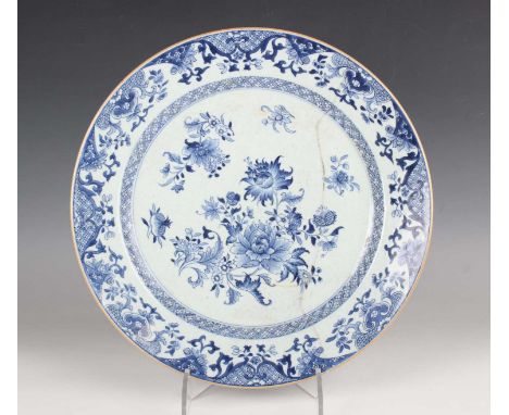 A Chinese blue and white circular dish, Qianlong period, painted with flower sprays within trellis and foliate scroll borders