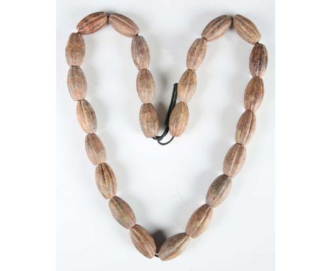 A Tibetan/Himalayan jade bead necklace, comprising twenty-four varicoloured swollen cylindrical beads with carved fluted deco