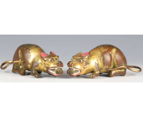 A rare pair of Tibetan gilt bronze figures of Nakula, 16th/17th century, each mongoose modelled in a crouching pose, grasping