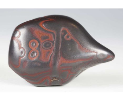 A Tibetan sacred stone relic, probably haematite, with natural markings, length 6.4cm, contained within a Tibetan damascened 