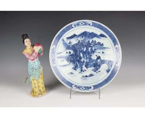 A Chinese blue and white porcelain circular dish, mark of Kangxi but late 19th century, painted with a figure crossing a brid