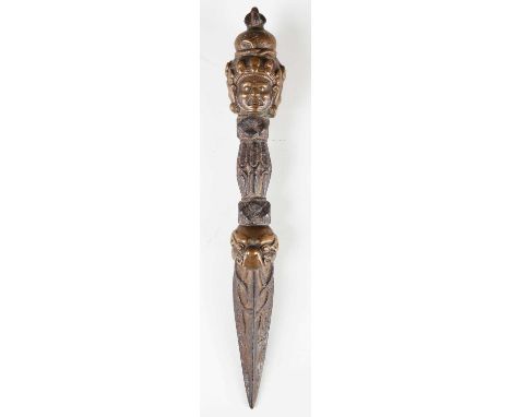 A Tibetan iron and bronze phurba, 17th century, the bronze pommel cast with the three heads of Vajrakila beneath a vajra crow
