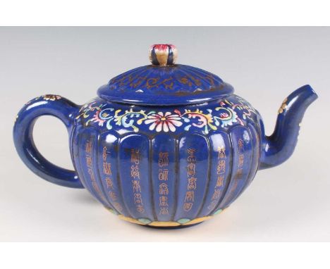 A Chinese blue enamelled Yixing stoneware teapot and cover, late 19th century, the fluted squat circular body decorated with 