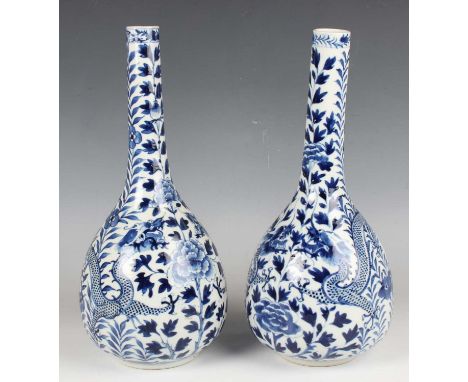 A pair of Chinese blue and white porcelain bottle vases, mark of Kangxi but late 19th century, each decorated with dragons am