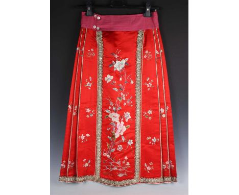 A Chinese red silk embroidered skirt, 20th century, worked in coloured threads with flowers within silver wire thread borders