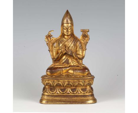 A Tibetan gilt bronze figure of Tsongkhapa, 17th century, modelled seated in dhyanasana with hands held in dharmachakra mudra