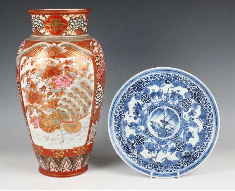 A Japanese Kutani porcelain vase, Meiji period, painted with opposing panels of figures and peacock amidst peony, reserved ag