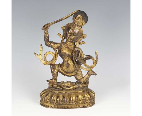 A Tibetan gilt bronze figure of Mahakala, 18th century, modelled wearing an ornate headdress and celestial scarf with right h