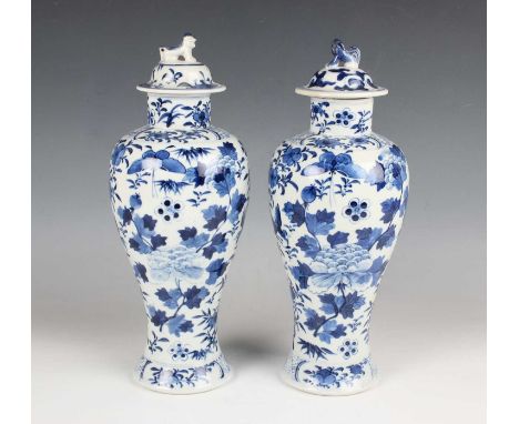 A pair of Chinese blue and white porcelain vases and domed covers, mark of Kangxi but late 19th century, each baluster body p