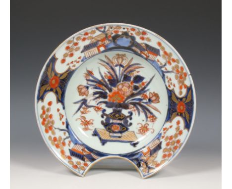 Japan, an Imari porcelain shaving basin, Edo period, late 17th century, the centre painted with a flower-vase, surrounded by 