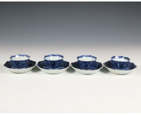 China, a set of four octagonal blue and white porcelain cups and saucers, 18th century, each painted with eight panels enclos