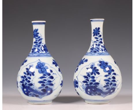 China, a pair of small blue and white porcelain bottle vases, Kangxi period (1662-1722), each with leaf-shaped panels enclosi