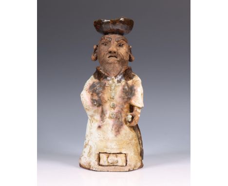 Japan, a pottery figural pricket candlestick, ca. 1900, modelled as a priest wearing long robe and cross, covered with brown 