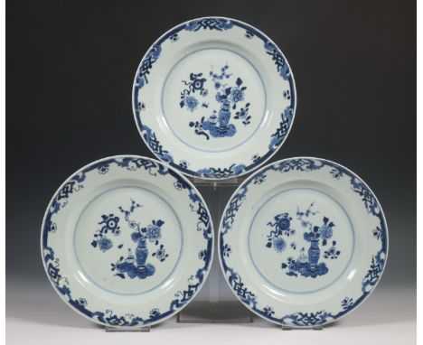 China, a blue and white porcelain dish, 19th century, and a set of three plates, 18th century, the dish painted with panels o